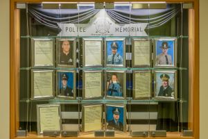 A display case features the photographs and bios of 7 fallen police officers