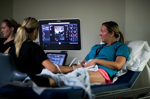 A Harper College student performs an ultrasound