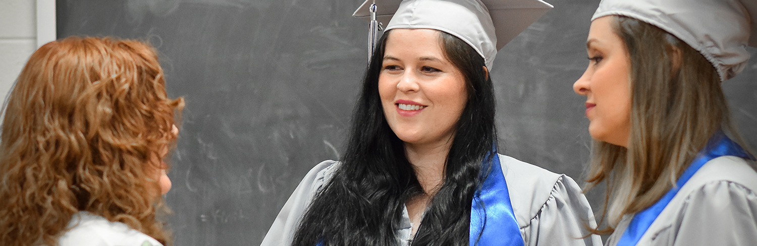 Students in graduation gowns with professor