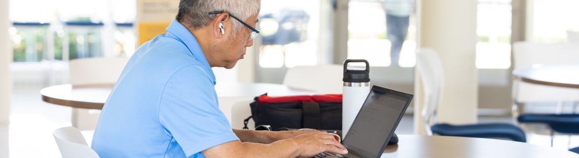 An adult student working on a laptop.