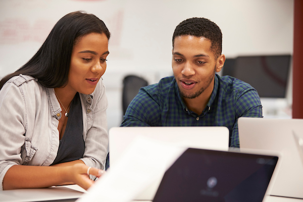 two students working on laptop