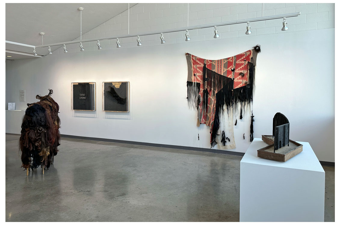interior gallery view with fiber arts piece hung on wall