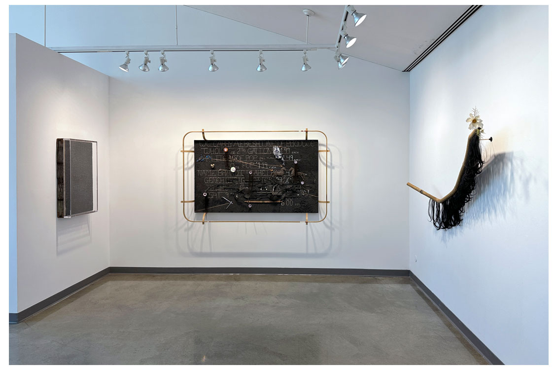 interior gallery view of three pieces of art hung on the wall