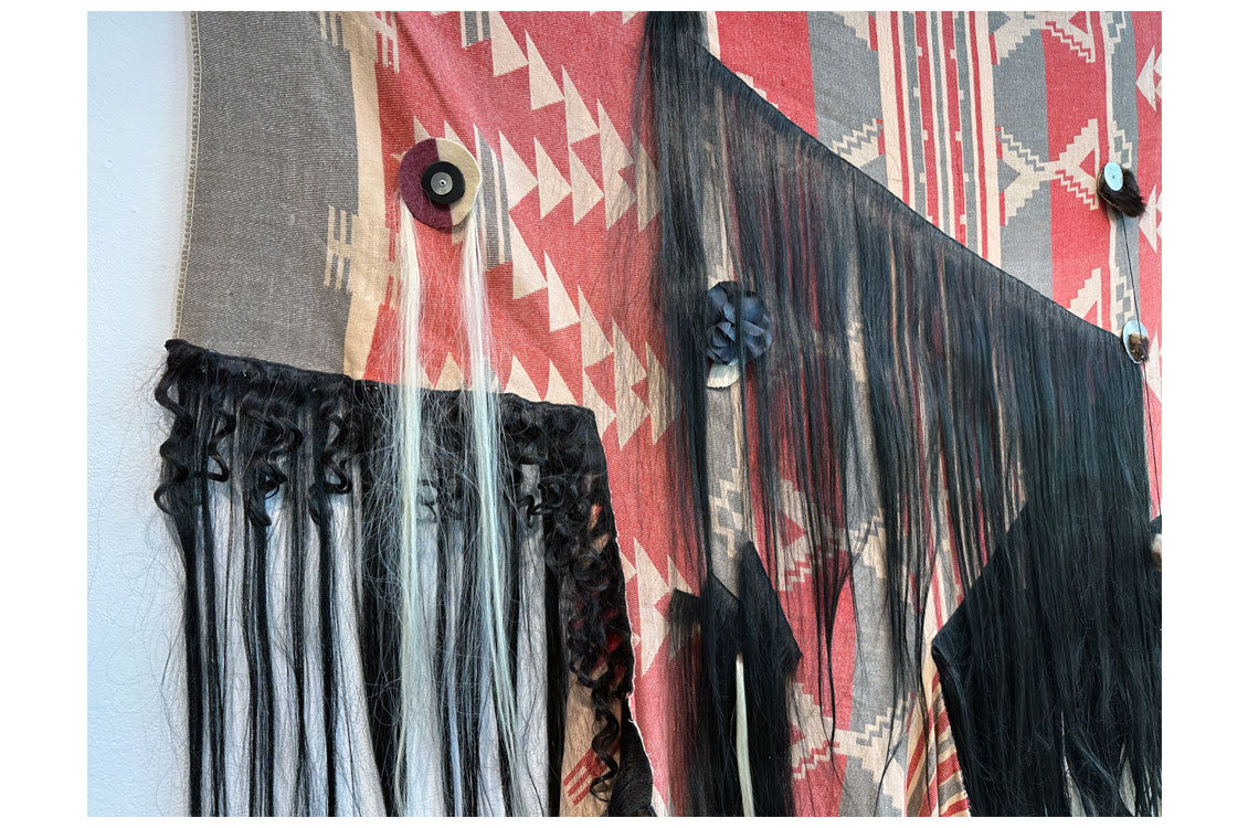 close up of woven piece, showing detail on black fringe