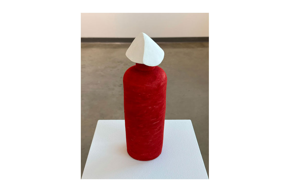 red cylindrical sculpture with white tip