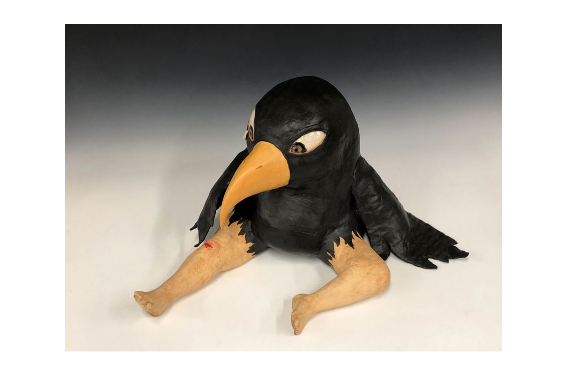 ceramic sculpture of a crow with human legs and an injured knee