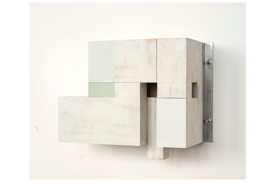 Whitewashed block sculpture on metal bracket with square openings.
