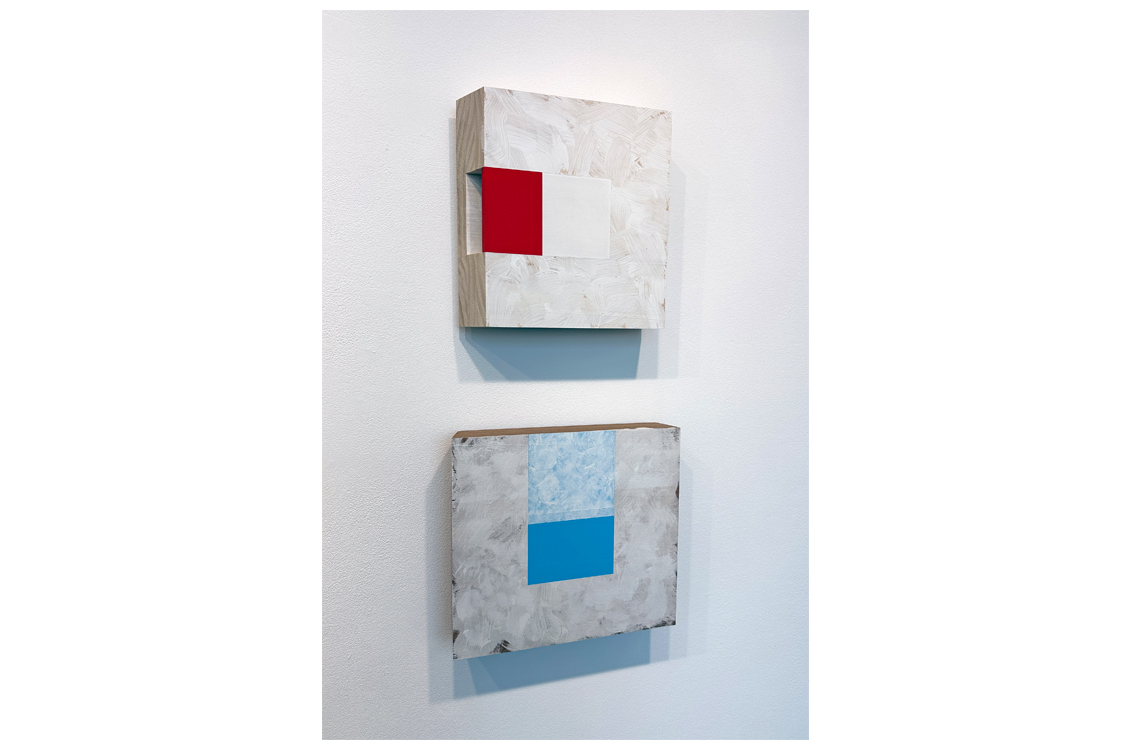 Two square wall works with bold red and blue painted rectangles.