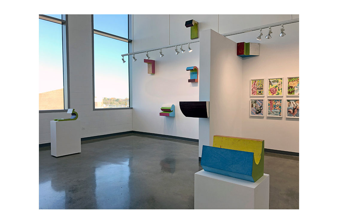 interior view of gallery with painted wood sculptures