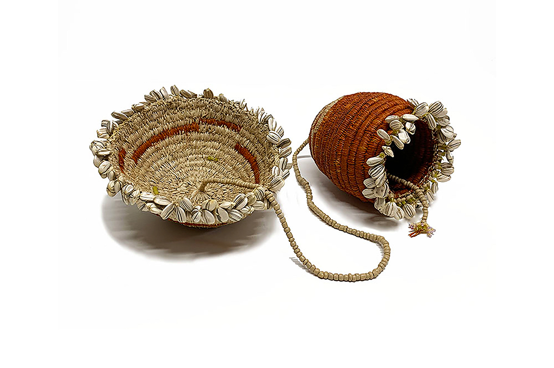 Two woven baskets connected by a beaded string.  The larger basket is flat and wide, and the smaller is tall, almost like a vase.