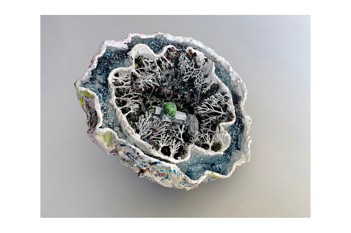 a geode sculpture with light blue and white crystals and a sculpture in the center
