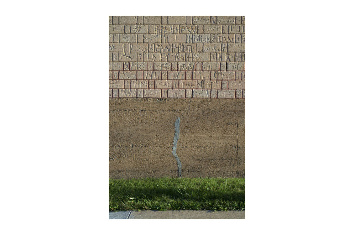 photograph of a crack in a sidewalk outside a building