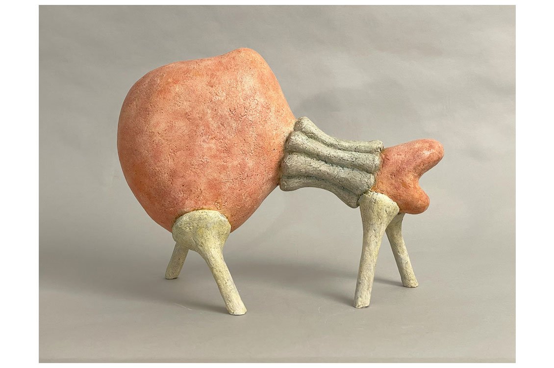 Abstract reddish-orange sculpture with rib-like connectors and gray legs, set against a plain background.