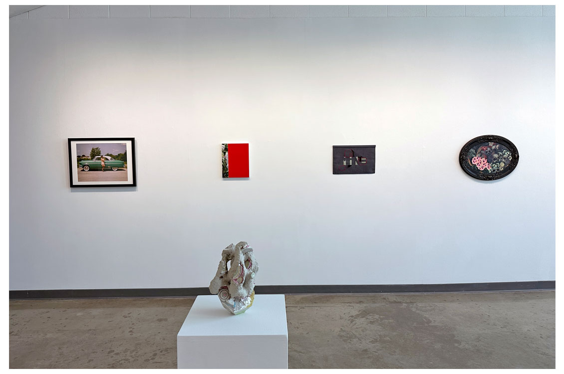four paintings on wall with sculpture in foreground