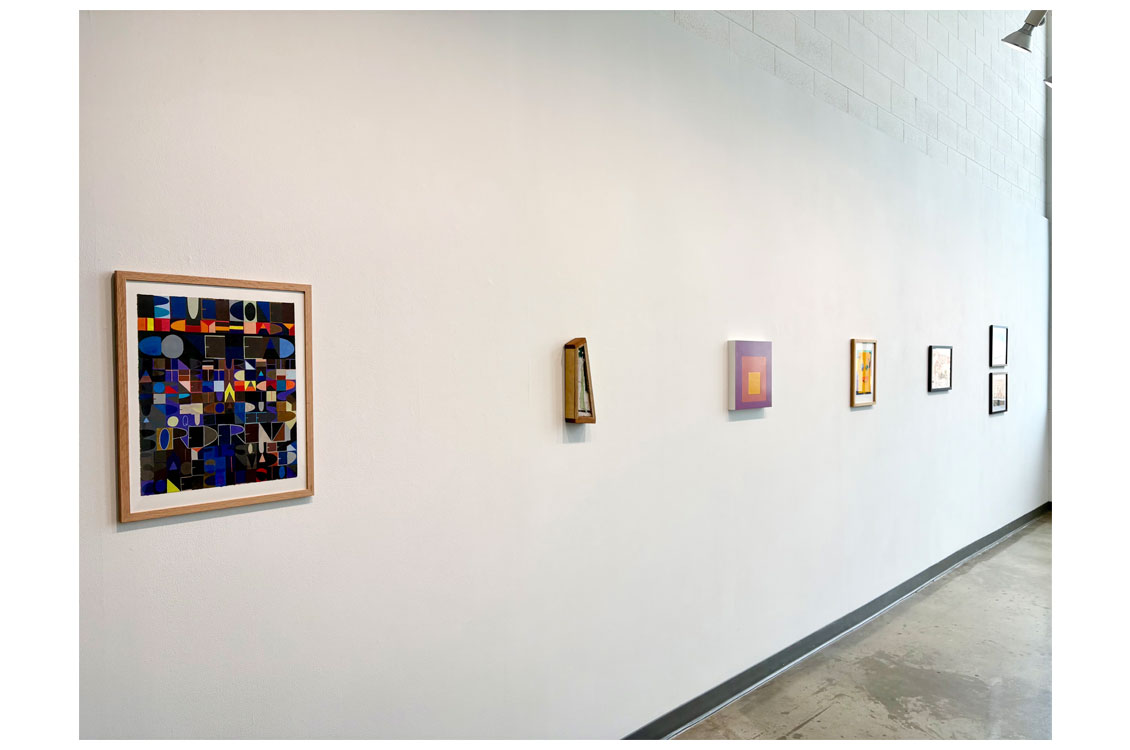 Long gallery wall with a large geometric collage and six smaller framed artworks.