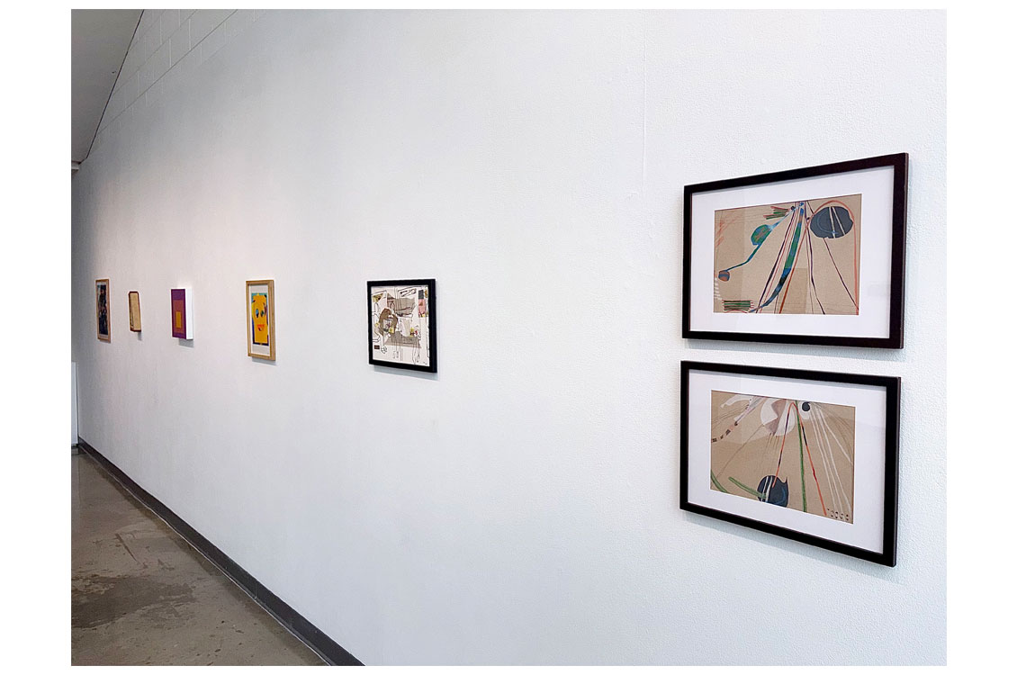 Gallery corridor with several small framed artworks and two larger framed line drawings.