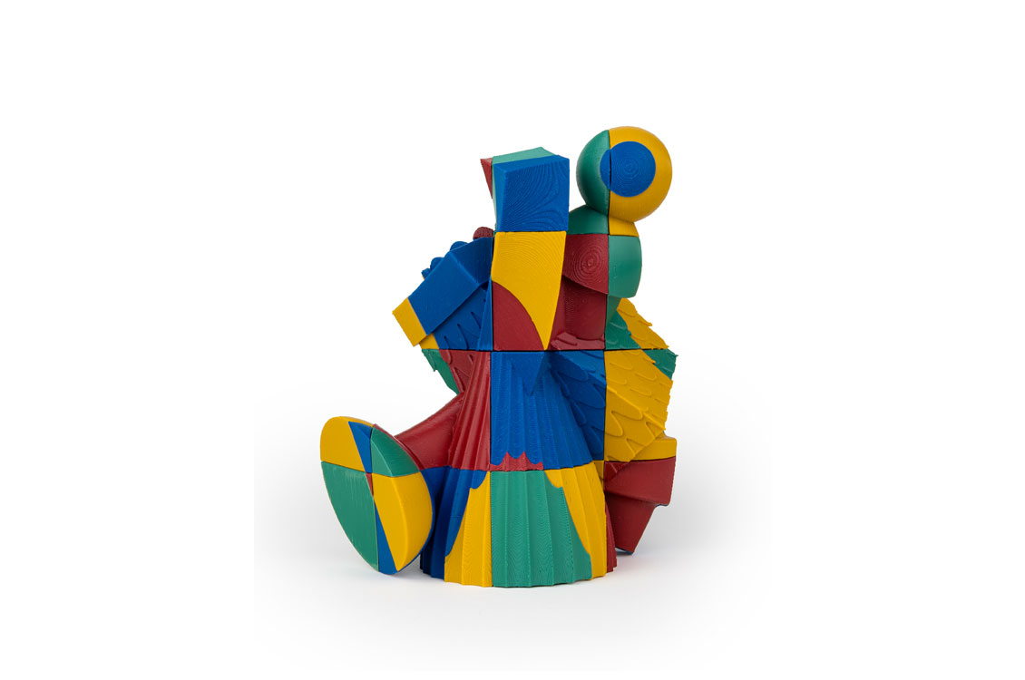 Abstract sculpture built from stacked geometric blocks in red, blue, yellow, and green.