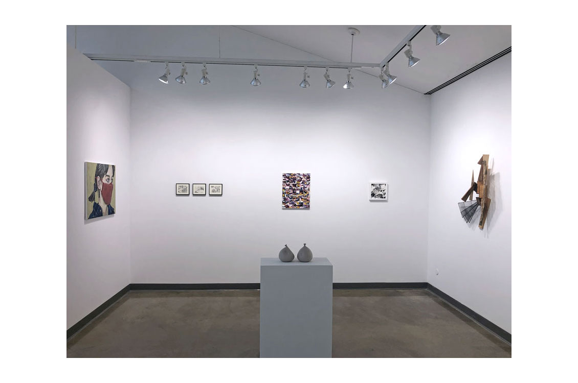 Interior gallery view with two pots on platform in center and paintings on wall behind