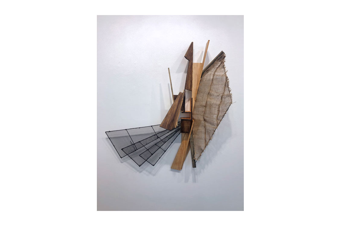 3d sculpture hung on wall, made of wood and mesh, with different geometric shapes