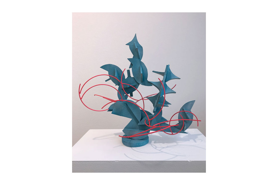 sculpture made of light blue wood in leaf shapes, with red wire around