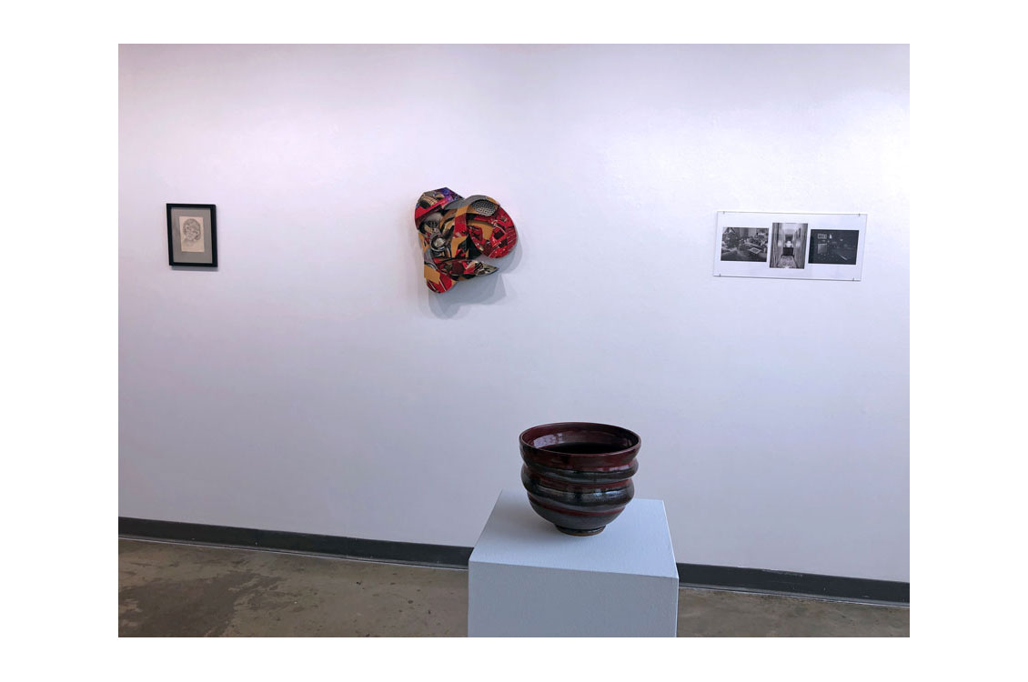 art gallery interior, with pot in center and paintings in background