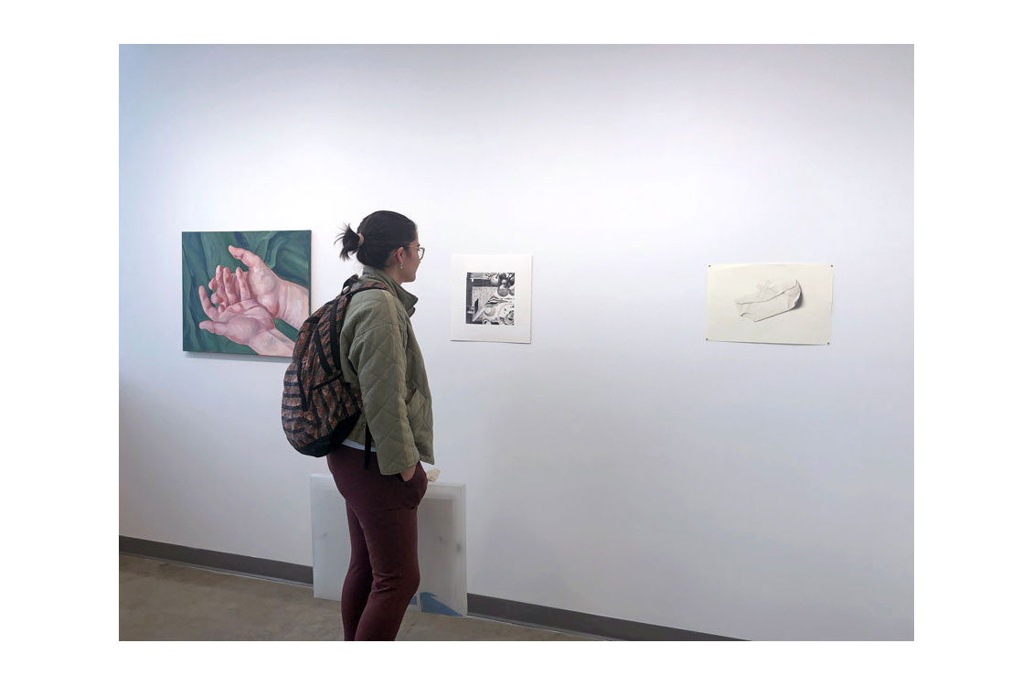 student viewing paintings in gallery