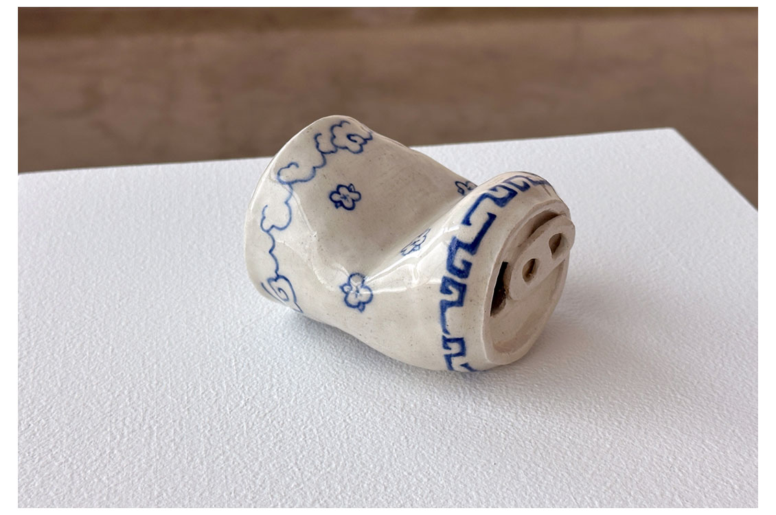 a ceramic sculpture of a partially crushed soda can