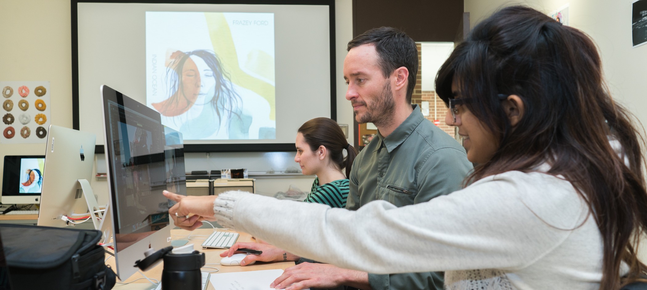 Associate in arts design degree student presenting her digital artwork to a professor.
