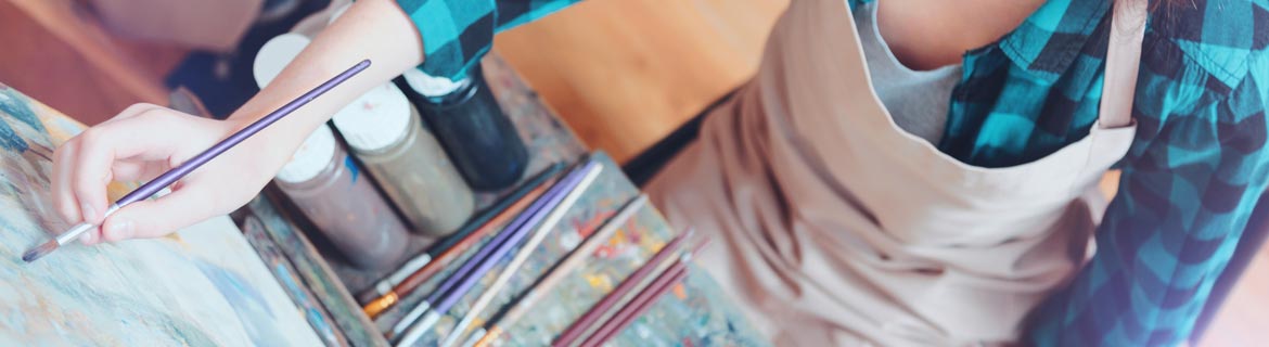 Student paints on a canvas.