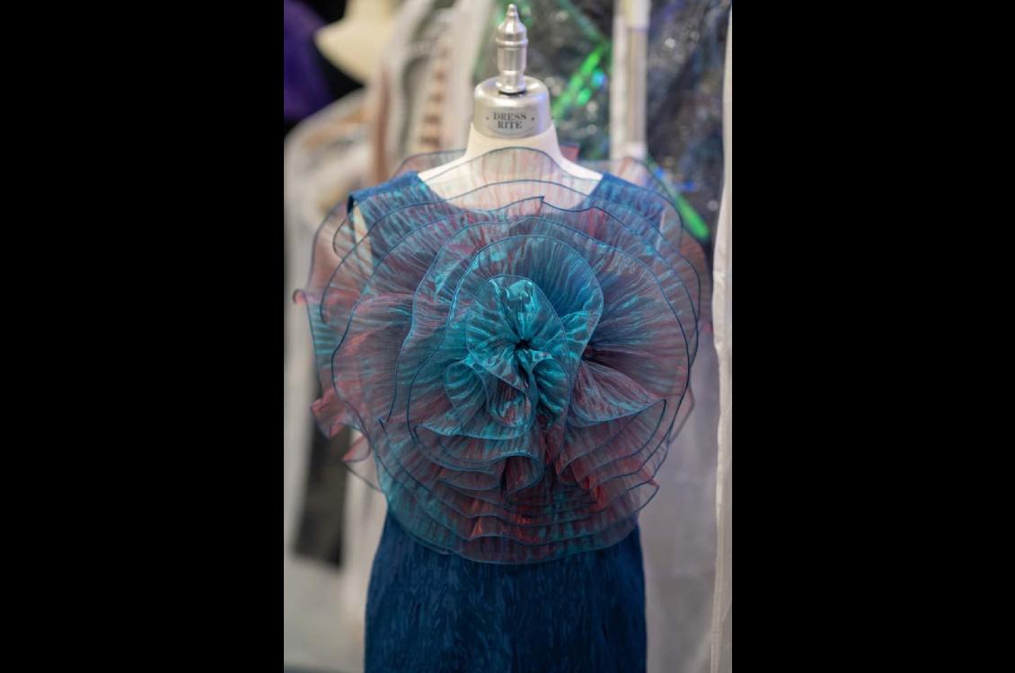 Iridescent blue dress on a mannequin before the show