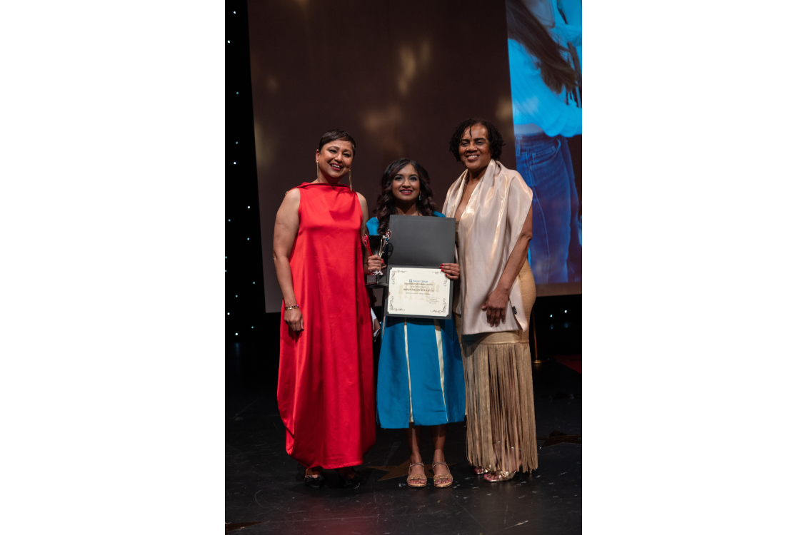 posing for the picture with an award three people