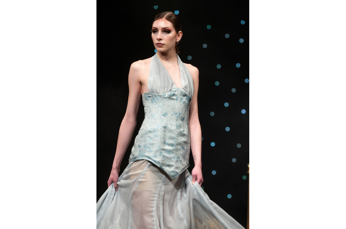 Model swinging dress on runway pose