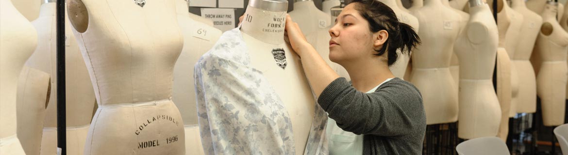 Student fits clothing onto a dress form.
