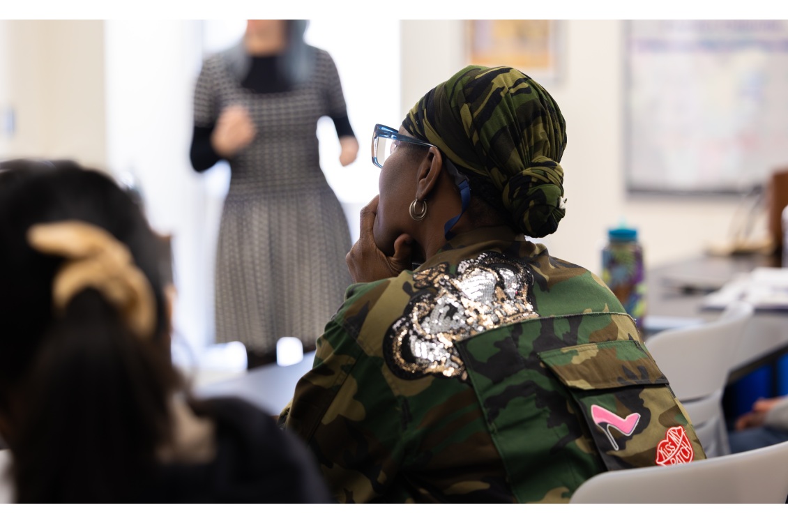 A Fashion Studies student sitting at a classroom table and listening to a presentation from Dr. Lelaine Rigatto