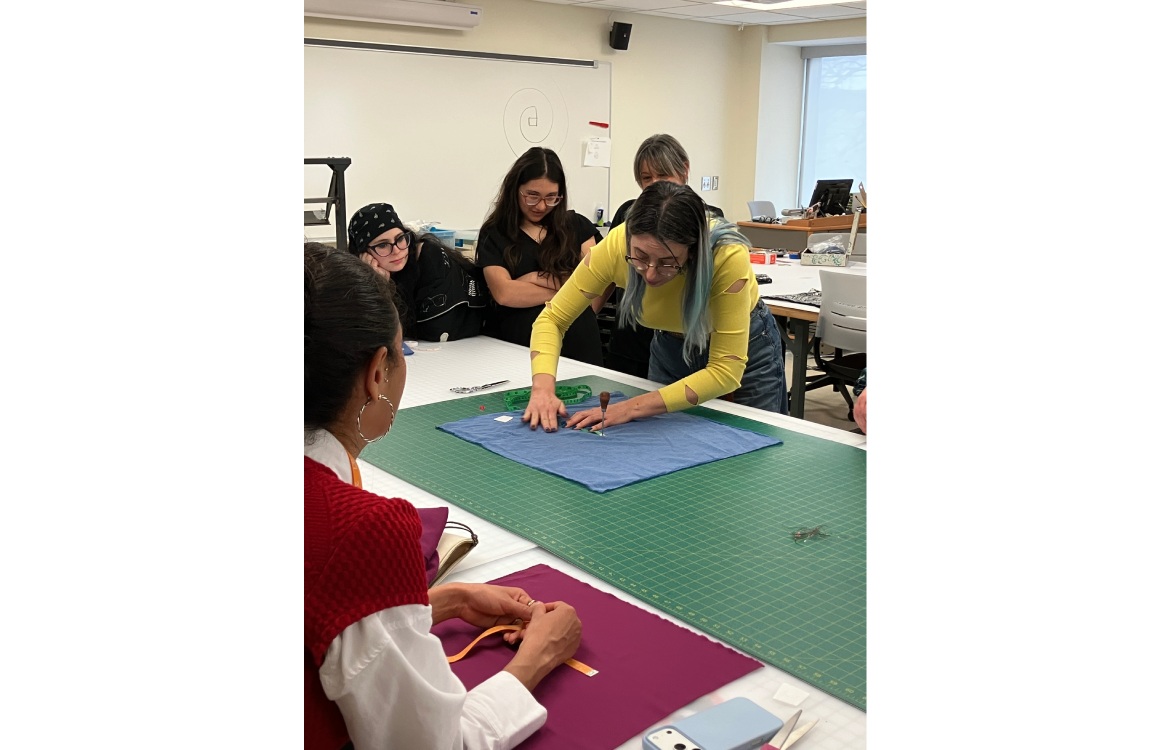 Dr. Lelaine Rigatto demonstrates cutting fabric on a large table