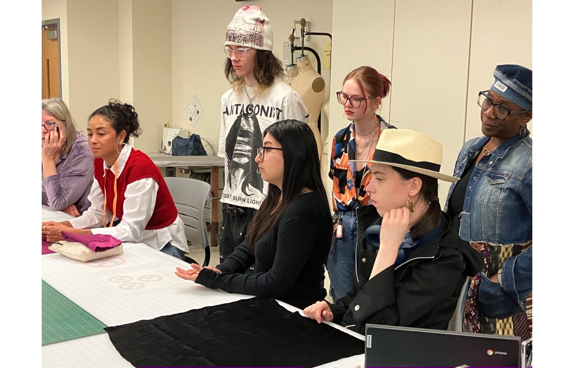 A group of Fashion Studies students sitting in a group and listening to a presentation