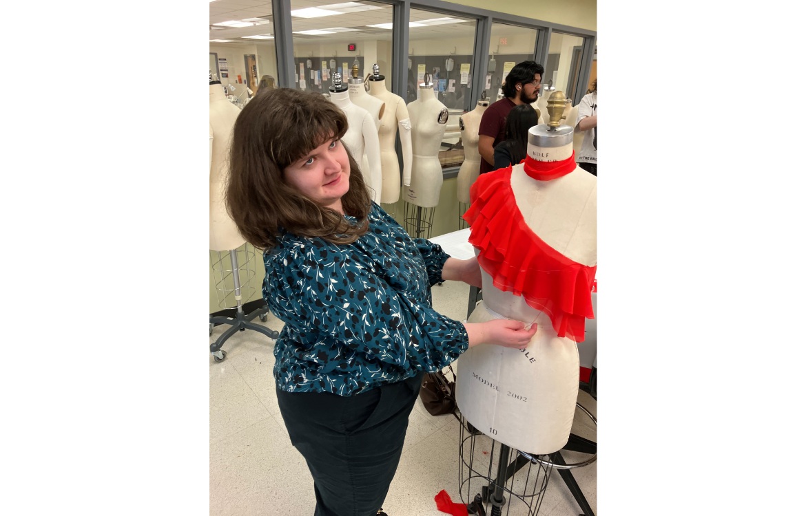 A Fashion Studies student examining fabric drapery on a mannequin