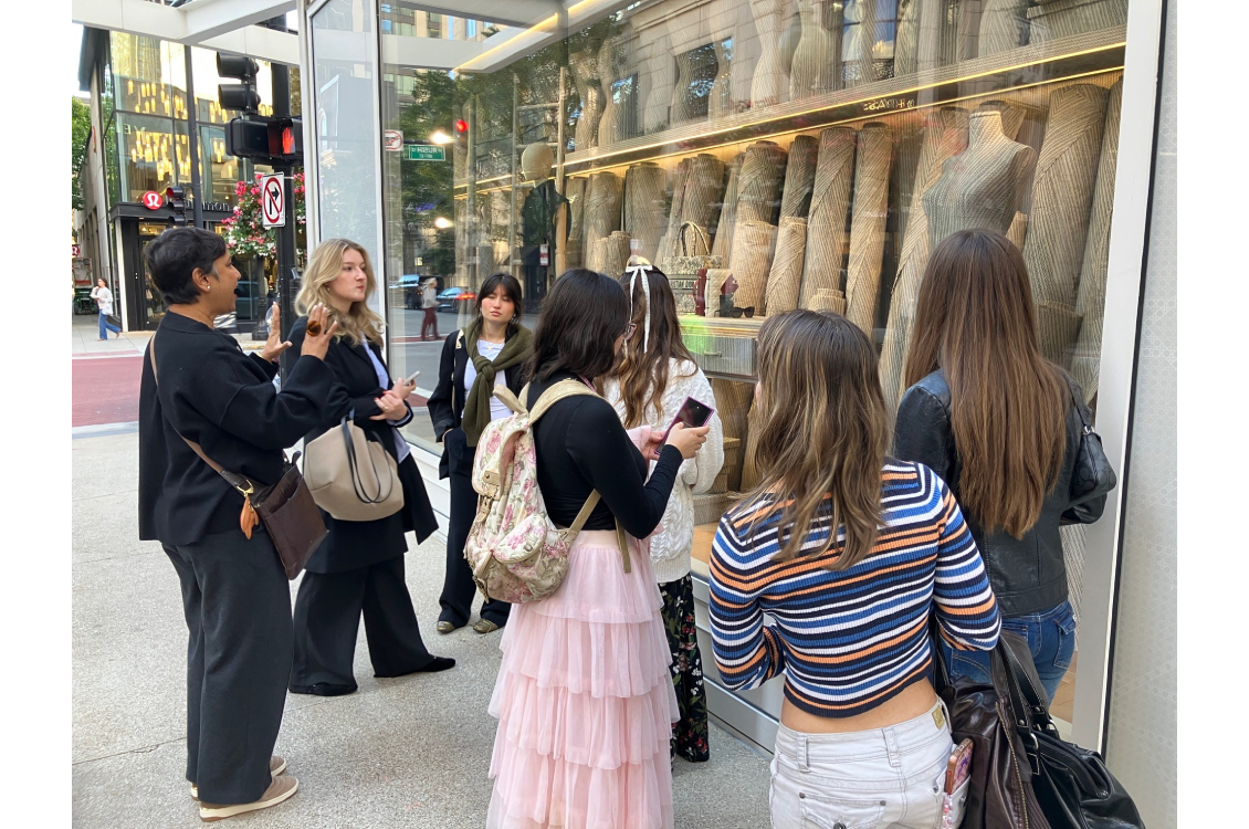 Visual merchandising students gather outside of a fashion window display on Michigan Avenue