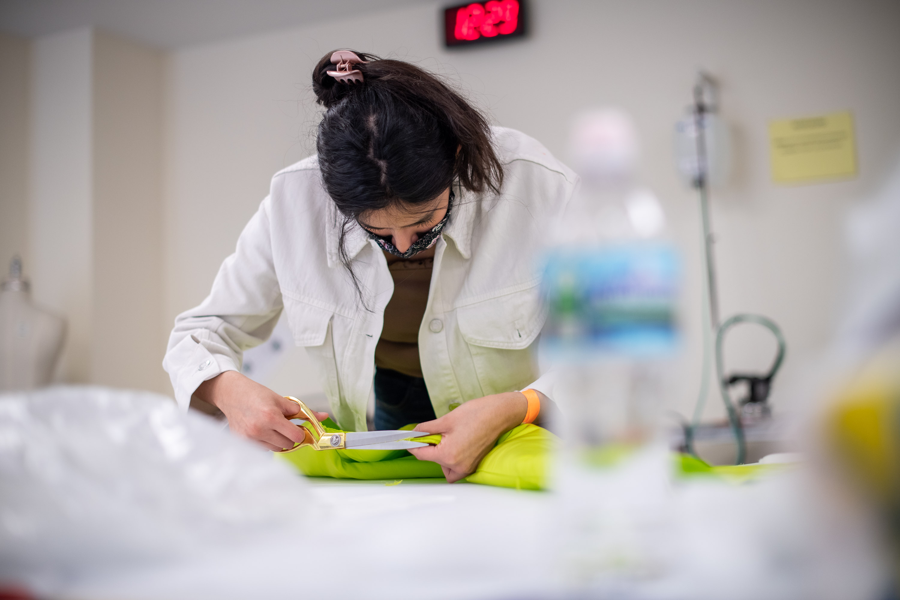 student cutting fabric