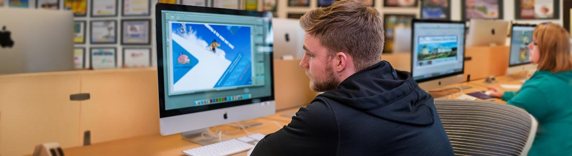 Student in the graphic arts program designing an image on an Apple computer.
