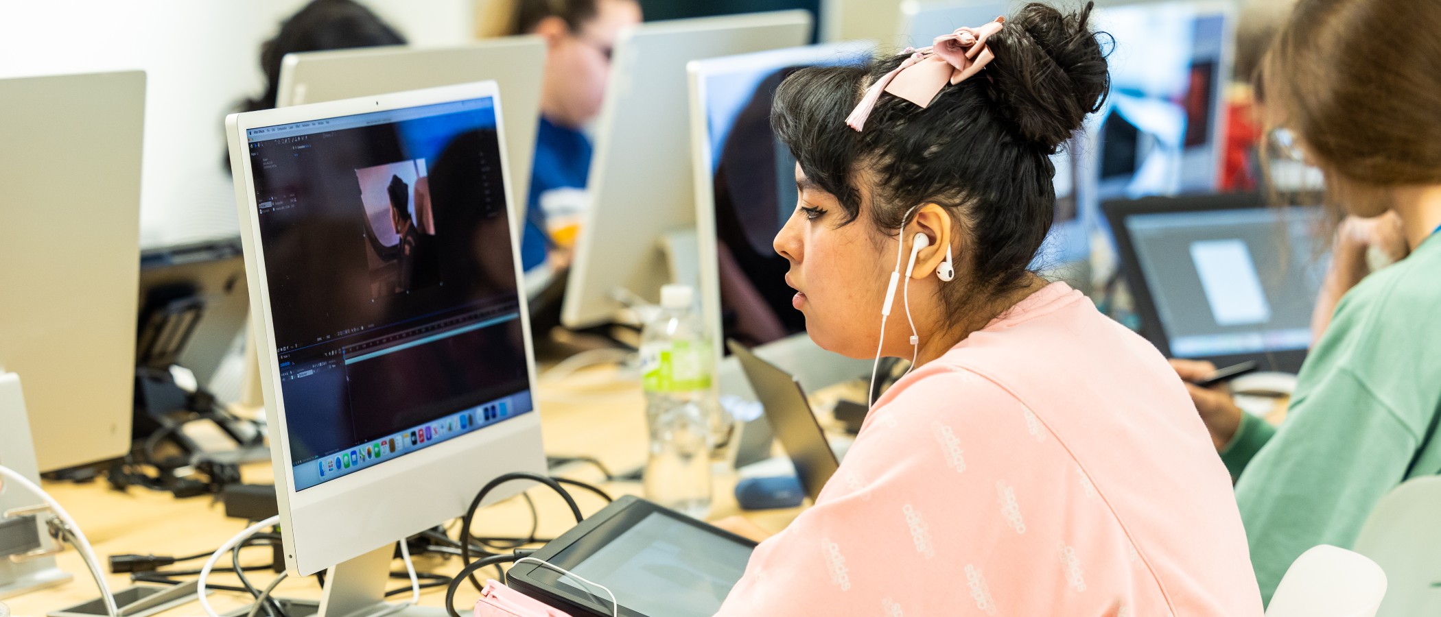 Harper Art student analyzing artwork at a computer desk.