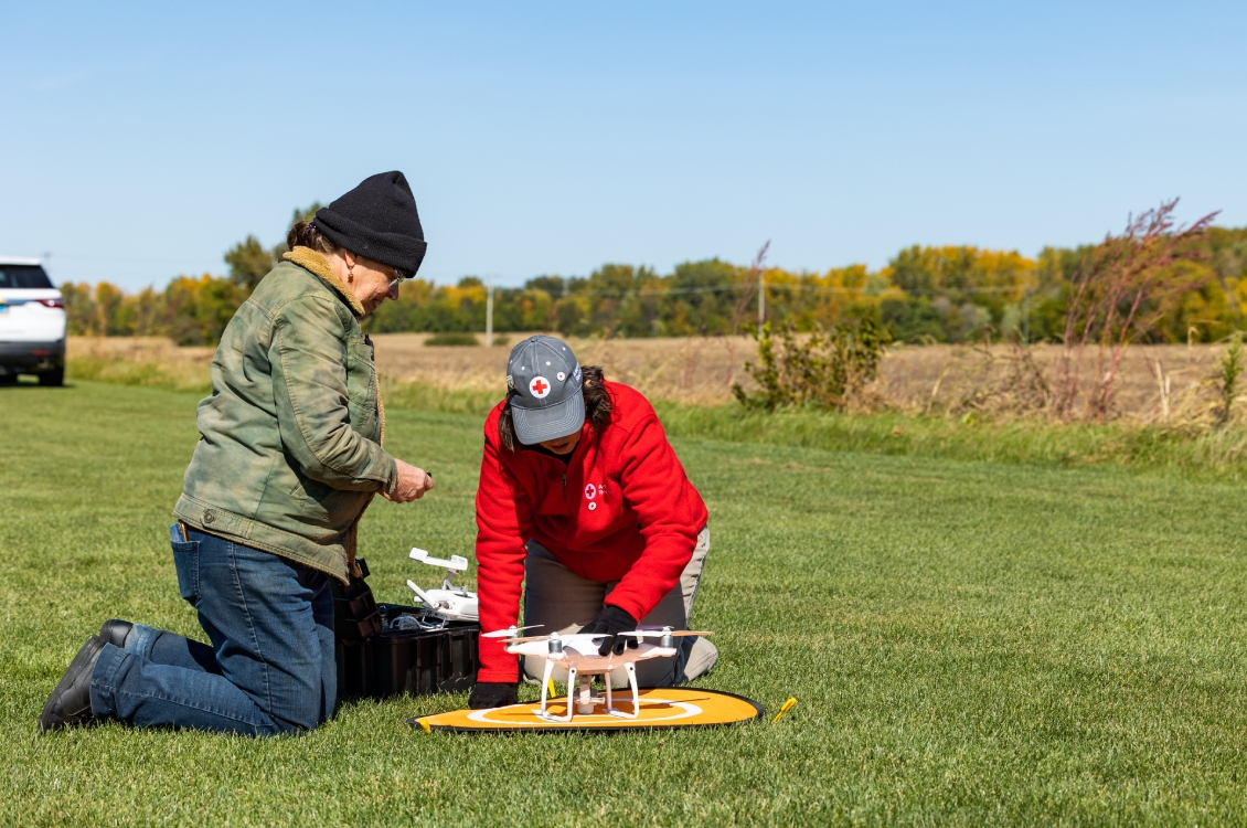A student checking the position of a drone on a landing pad.