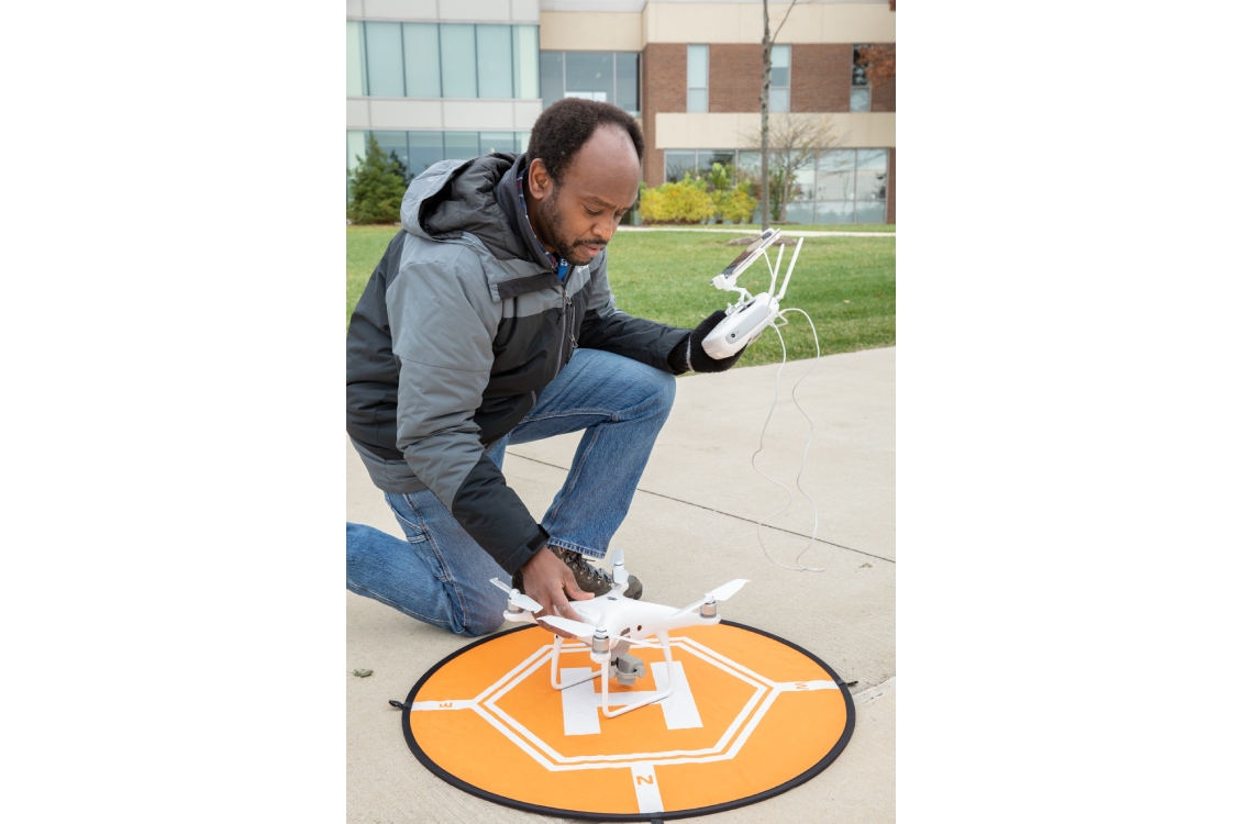 GIS/Drone Technology Program Coordinator Mukila Maitha setting up a drone for a test flight.