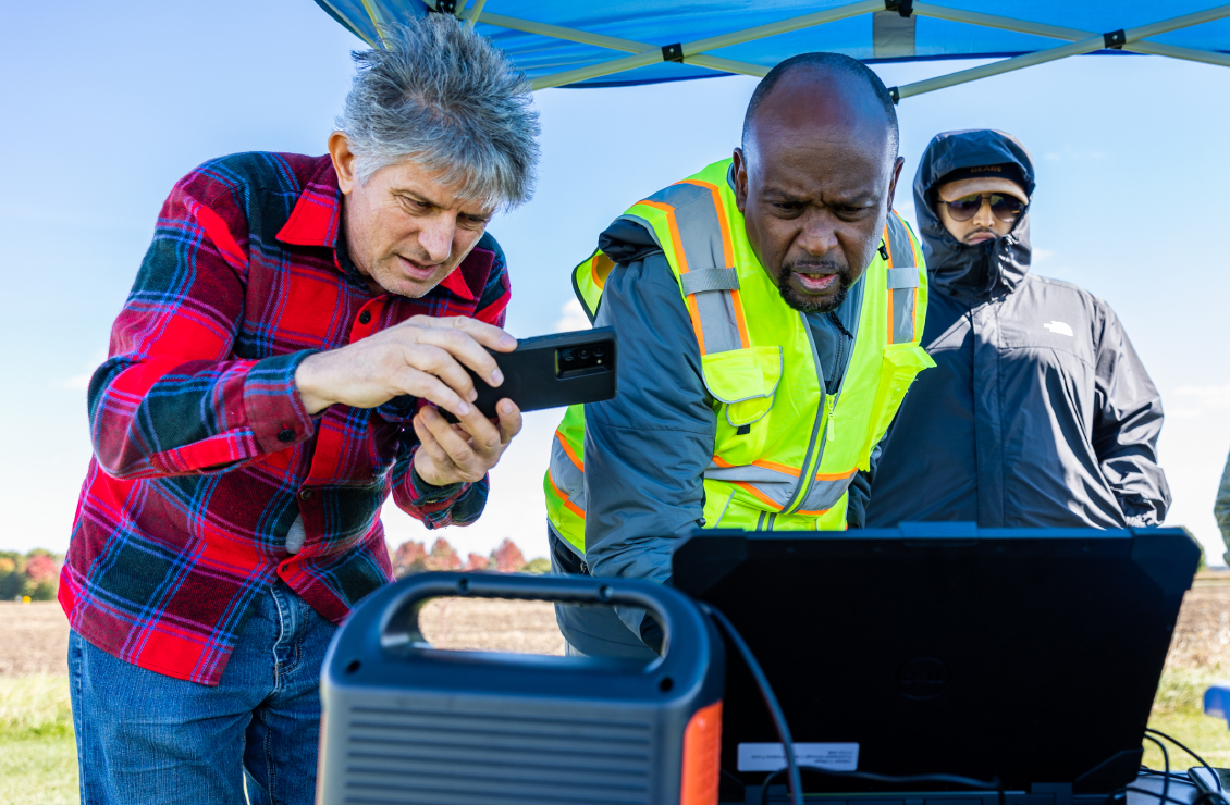 A GIS/Drone Technology student using his phone to record the map displayed on the laptop.