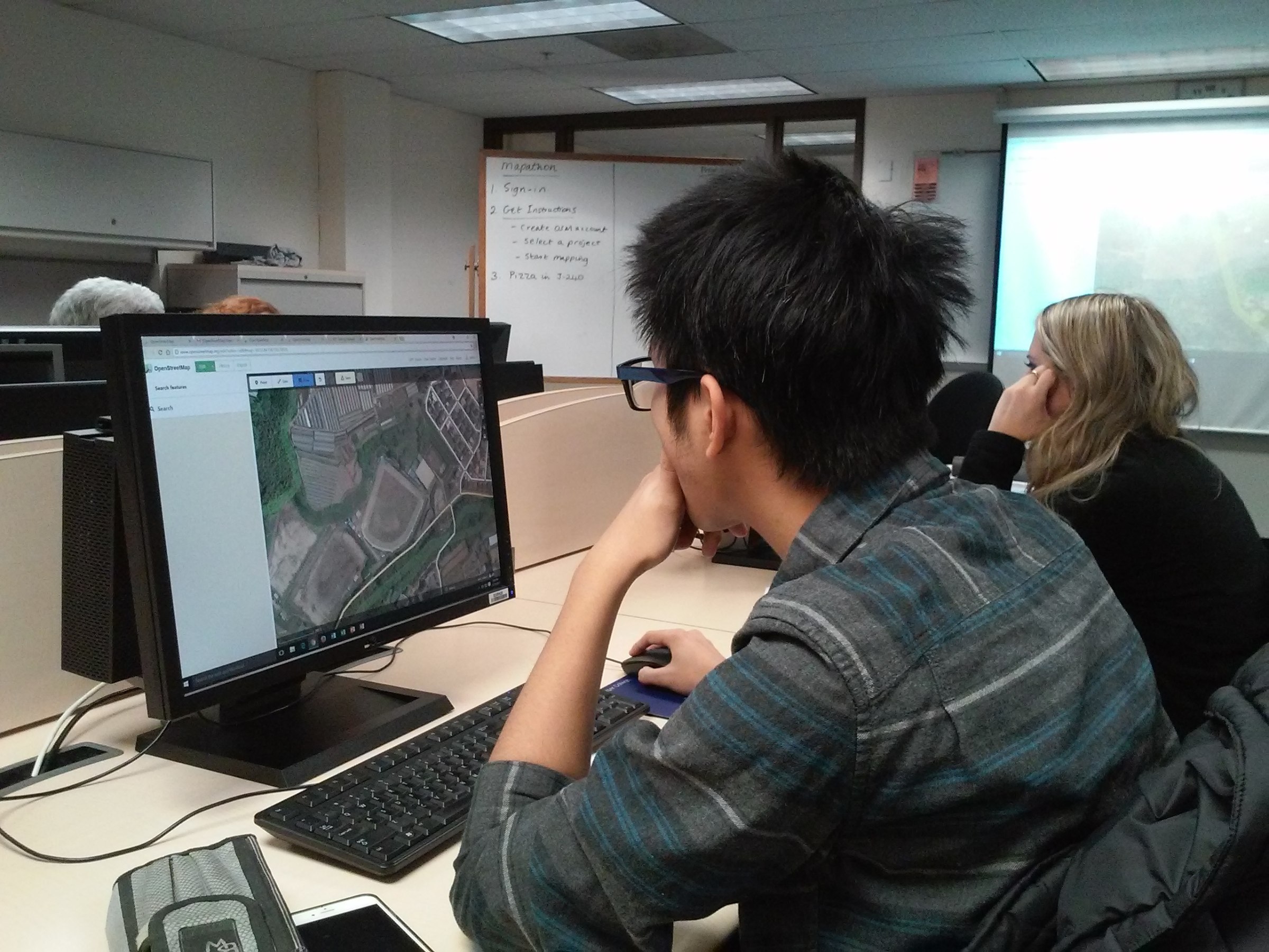 A GIS/Drone Technology student looking at the Harper College map on a computer in a classroom