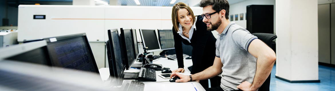 Woman helping man use computer