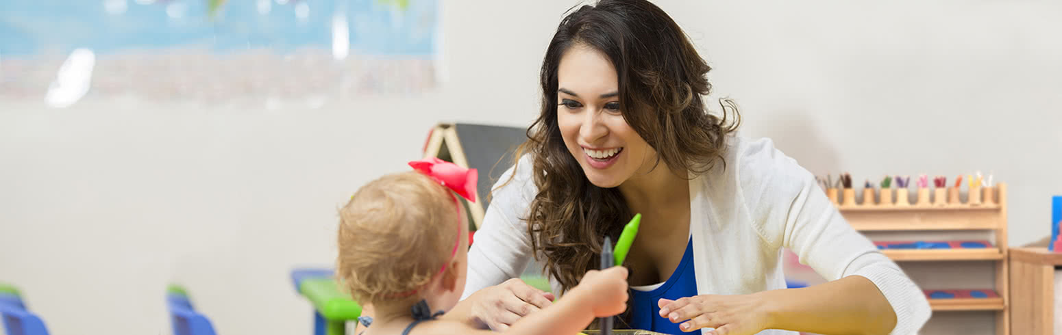 Early Childhood Education degree student drawing with a young child in a classroom.