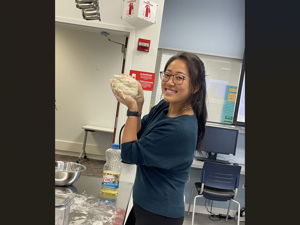 A Dietetic Internship student holds dough in Nutrition Lab