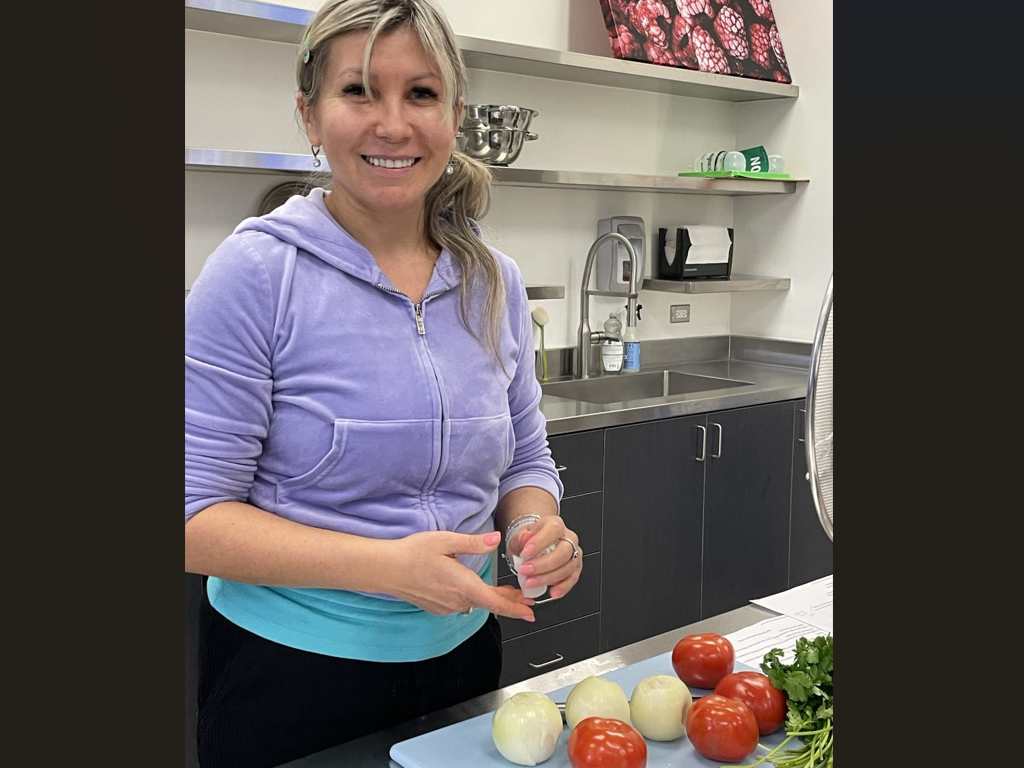 Student works with tomatoes and onions in Nutrition Lab