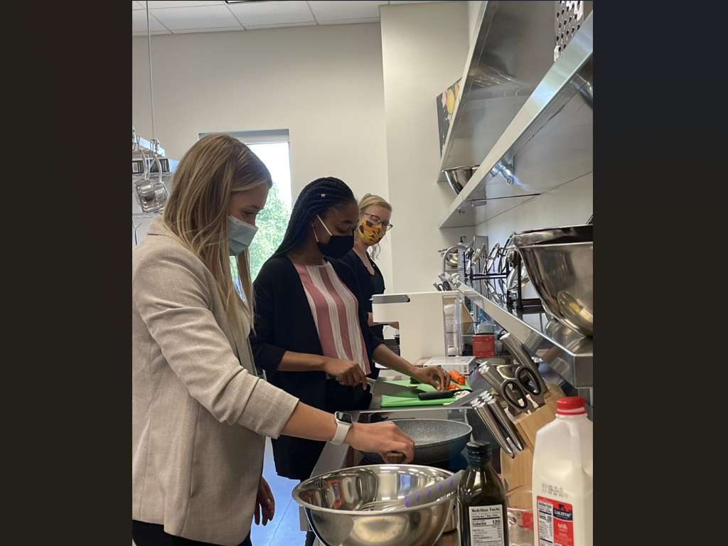 Students wearing face masks work with food in large bowls in the Nutrition Lab